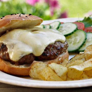 bilde av tallerken med cheeseburger , chips og grønnsaker